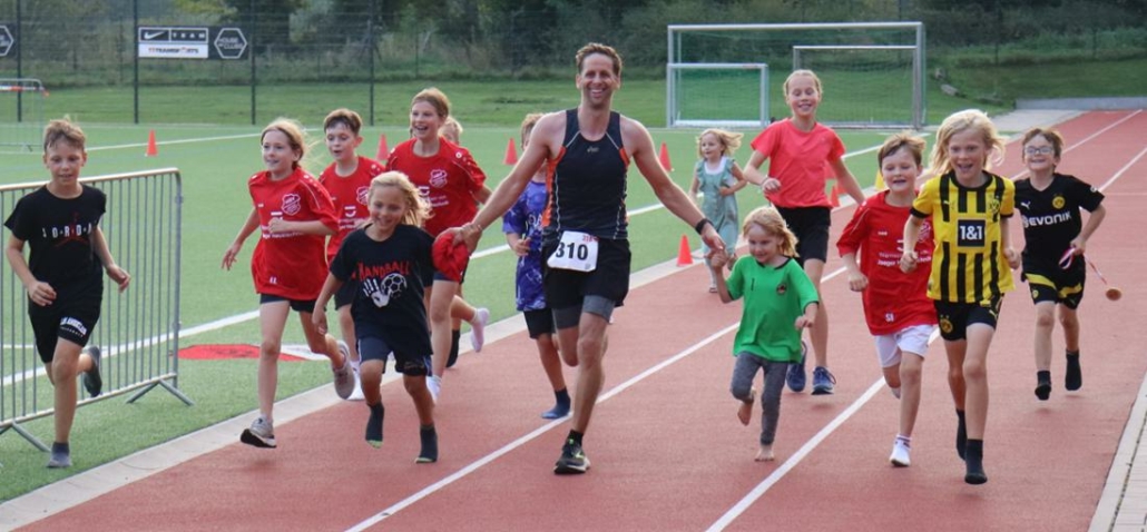 Dennis Hofmann vom Höinger SV wurde auf der Zielgeraden des 19,24-km-Laufs von zahlreichen Kindern begleitet.